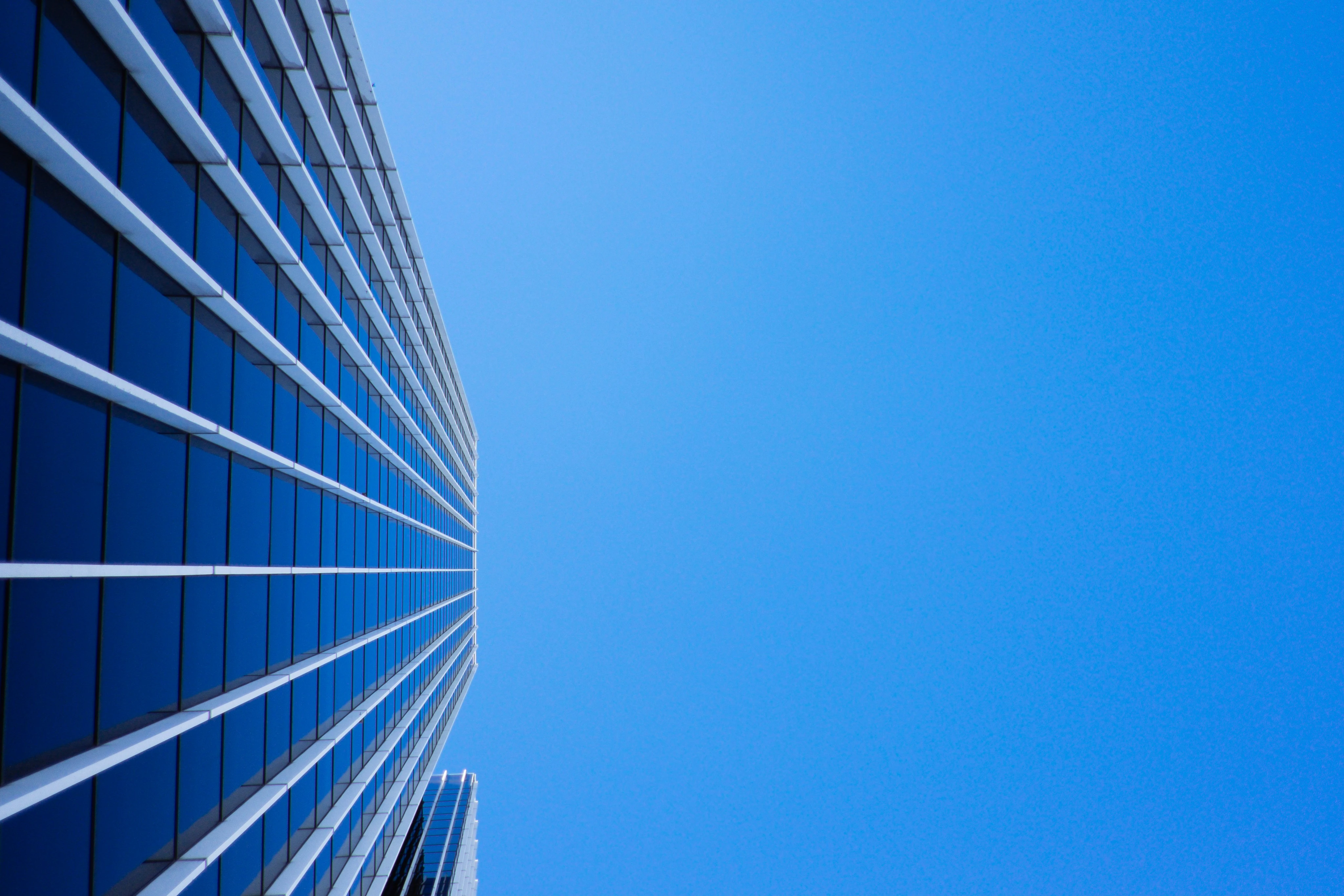 Modern glass building reaching toward blue sky - symbolizing innovation and growth